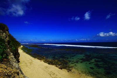 Scenic view of beach against blue sky
