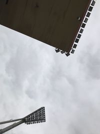 Low angle view of floodlights against sky