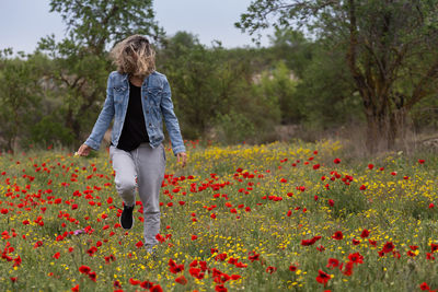 Full length of woman standing on flowering plants