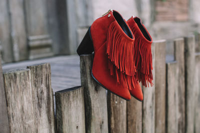 Close-up of red wooden post hanging on fence