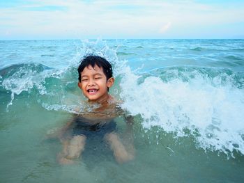 Smiling boy swimming in sea
