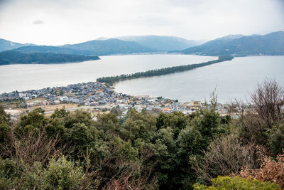 High angle view of townscape by sea against sky