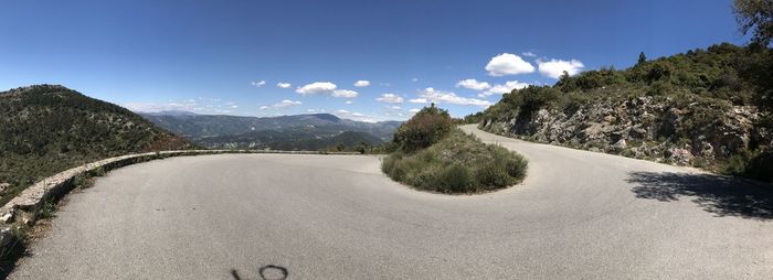 Road by mountains against blue sky