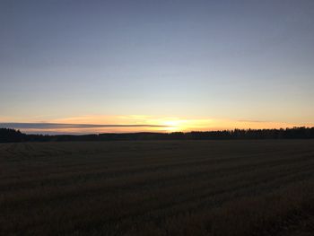 Scenic view of field against clear sky during sunset