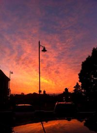 Silhouette of street light against cloudy sky