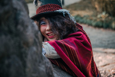 Portrait of man cosplaying mad hatter looking into camera outdoors