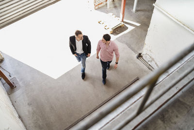 Bird's eye view of two men walking at loading bay in a factory