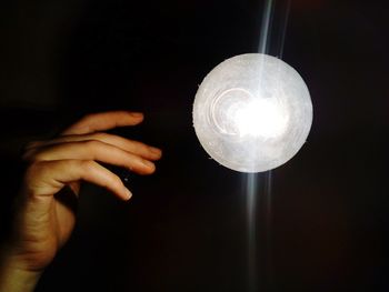 Close-up of hand holding illuminated light bulb