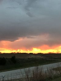 Scenic view of field against dramatic sky