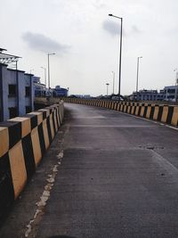 Empty road against sky in city