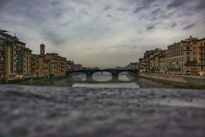 Bridge over river in city against sky