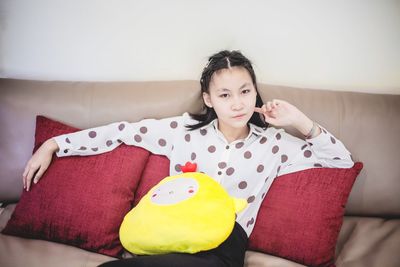 Portrait of woman sitting on sofa at home