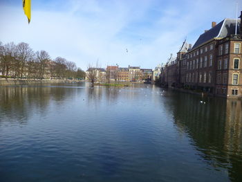 River by buildings in city against sky