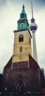 Low angle view of bell tower against cloudy sky