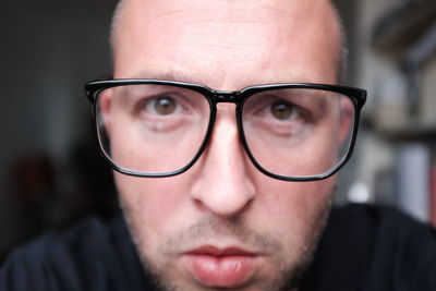 Close-up portrait of man wearing eyeglasses at home