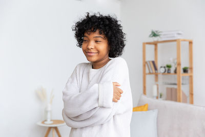 Portrait of young woman standing against white background