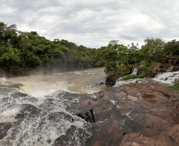 Scenic view of waterfall against sky