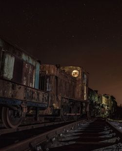 Train on railroad tracks against sky at night