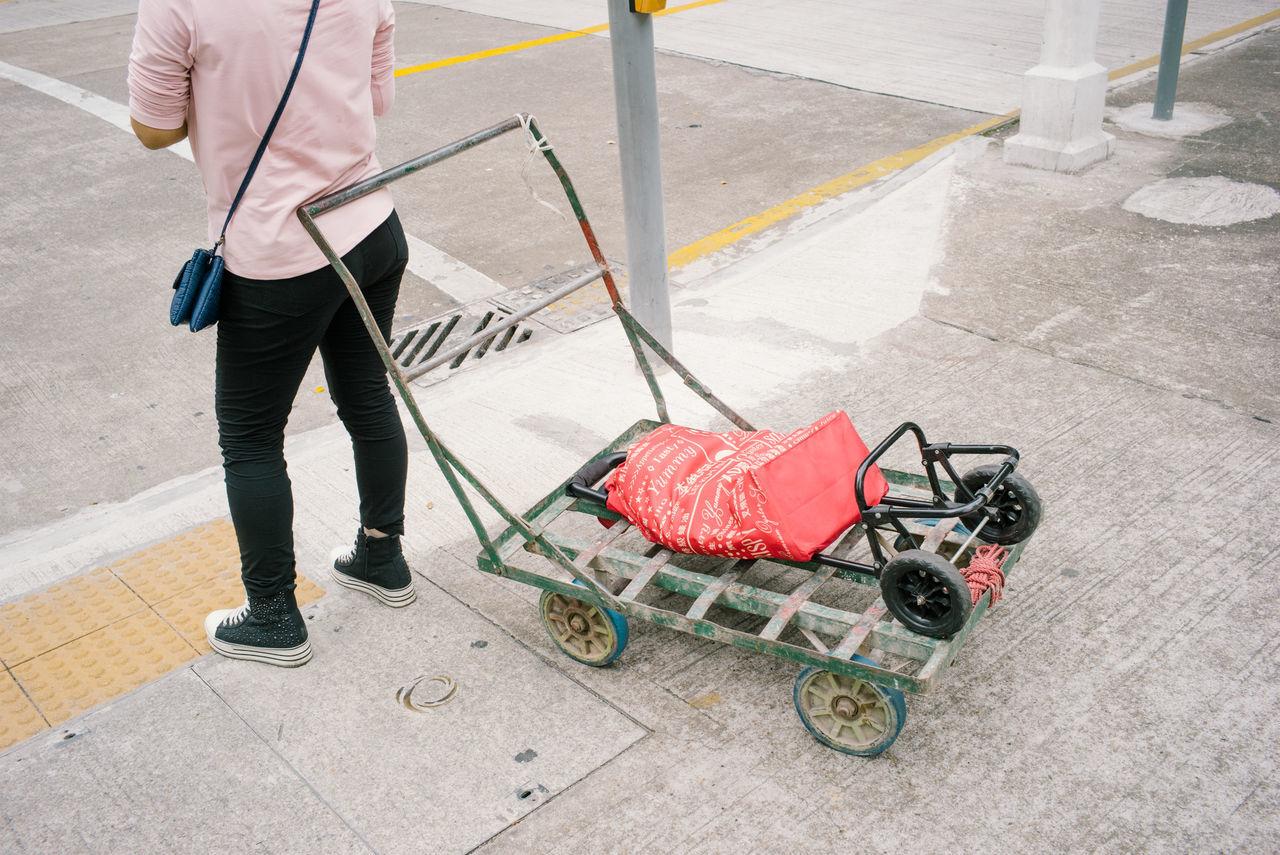 one person, one man only, human body part, adults only, only men, working, men, low section, sidewalk, cleaning, occupation, people, human hand, manual worker, adult, one young man only, shopping cart, day, outdoors, young adult, cleaning equipment, reflective clothing