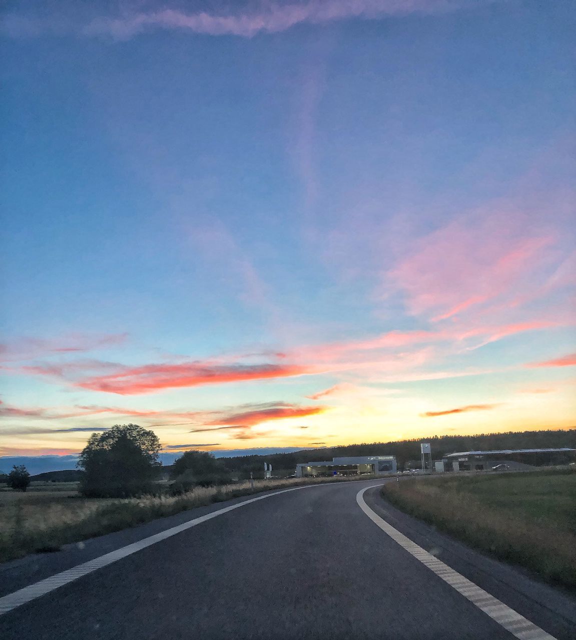 ROAD AMIDST LANDSCAPE AGAINST SKY DURING SUNSET