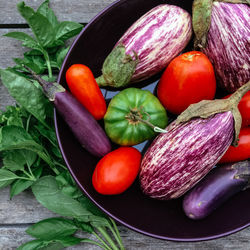 Directly above shot of tomatoes with eggplants and chili peppers in bowl