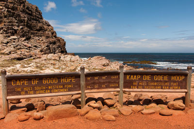 High angle view of information sign on shore against sky