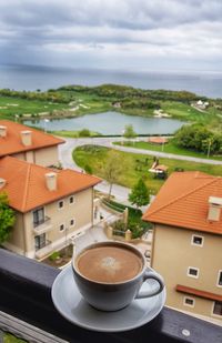 High angle view of coffee and buildings on table against sky