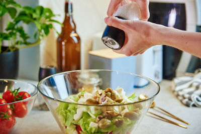 Woman prepare green vegetable salad in bowl at kitchen