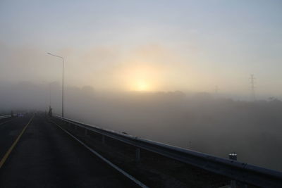 Bridge over road against sky during sunset