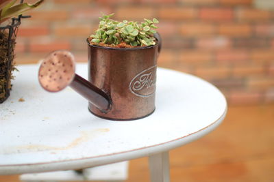 Close-up of small watering can on table