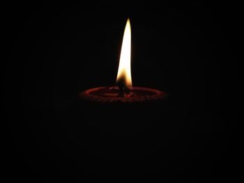 Close-up of illuminated candle against black background