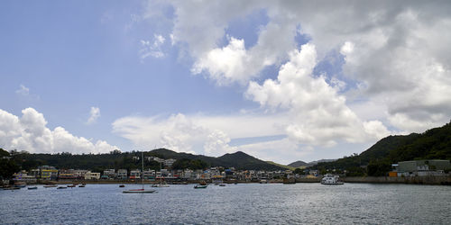 Scenic view of sea by buildings against sky