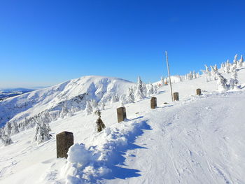 Scenic view of snowcapped mountains against clear blue sky