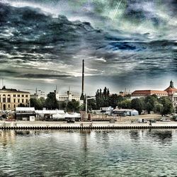 River in city against cloudy sky