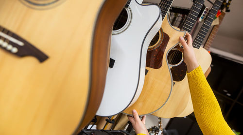 Cropped hand of woman holding guitars