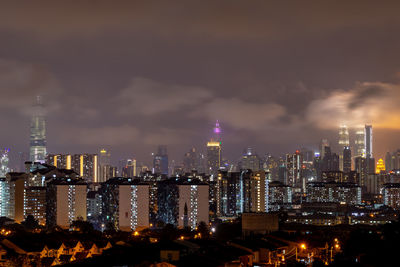 Illuminated cityscape against sky at night