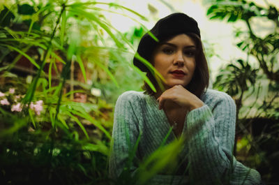 Portrait of young woman against trees