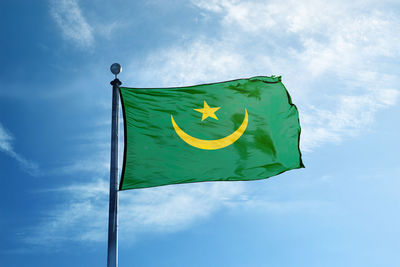 Low angle view of flag against blue sky