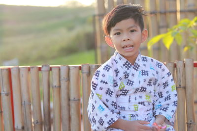 Asian boy wearing uniform japan background bamboo fence mountain view  light sunlight nature evening