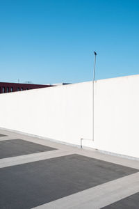 Empty car park against clear blue sky