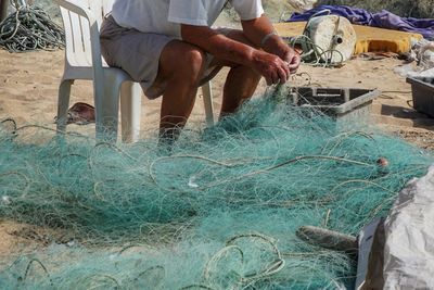 Low section of men working on fishing net