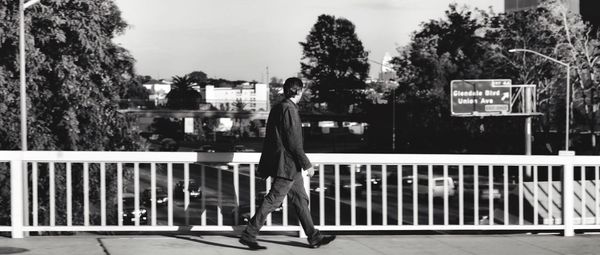 Woman standing by railing against sky