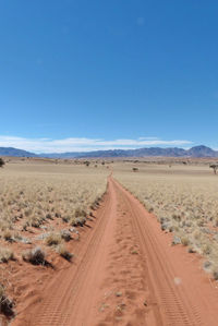 Scenic view of desert against clear blue sky