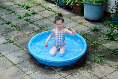 Young girl playing in the pool in the backyard