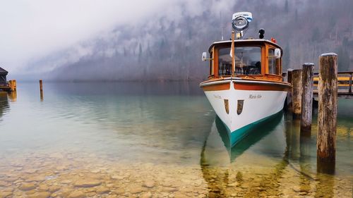 Boat moored in lake against sky