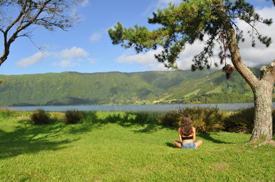 Rear view of man relaxing on lake