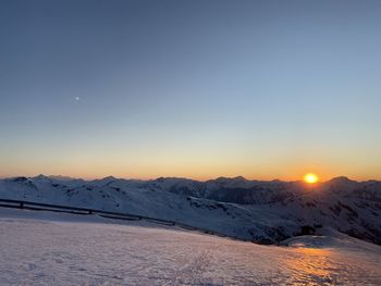 Scenic view of snow covered mountains against sky during sunset