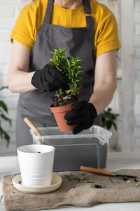 Midsection of man holding potted plant