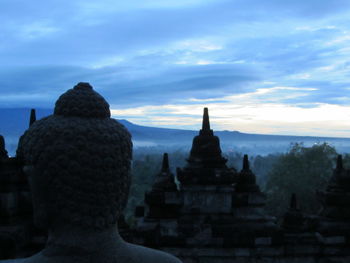 Statue of temple against cloudy sky