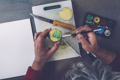 Directly above view of man painting on fruit